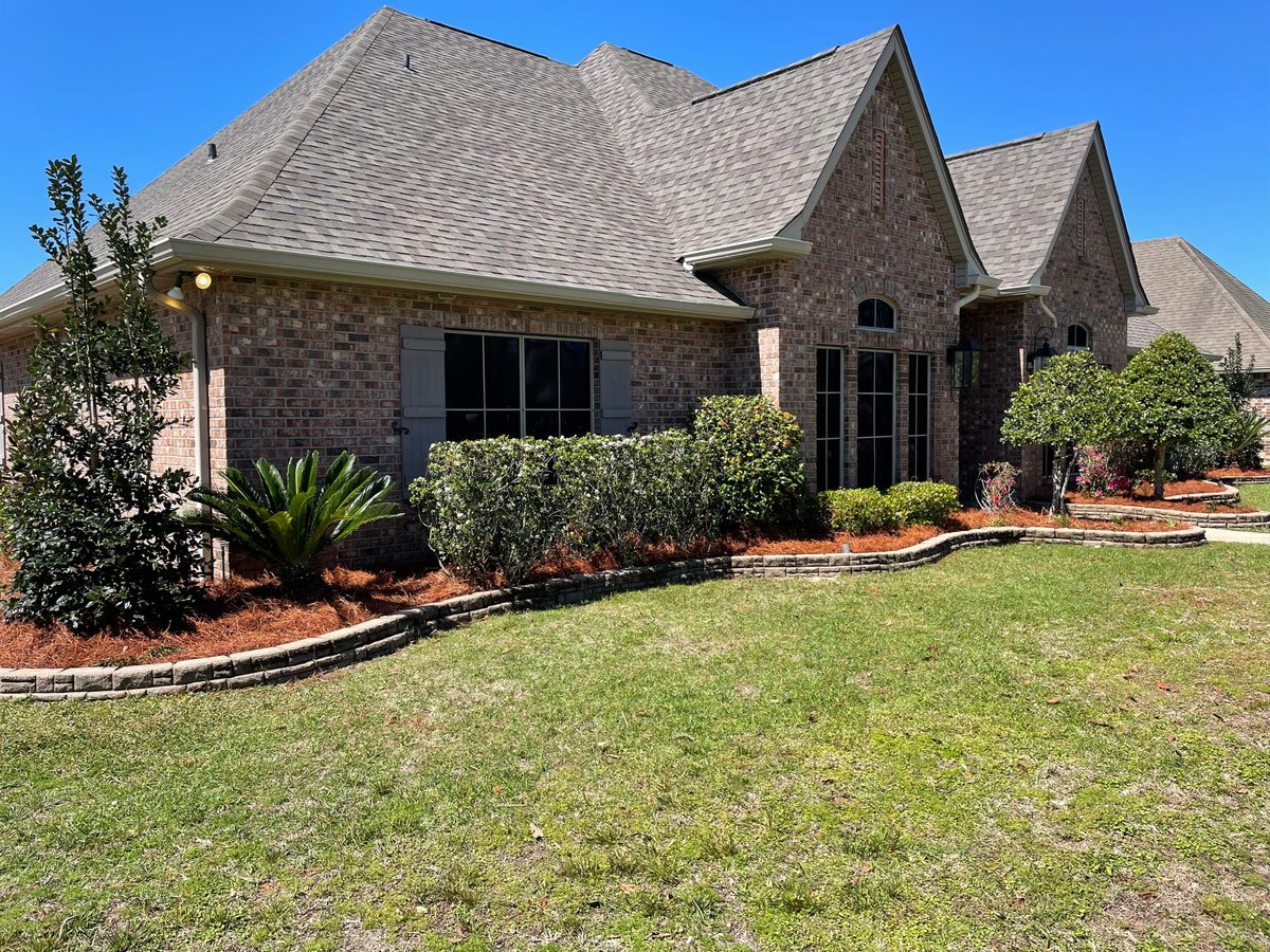 Curved red mulch landscaping beds with stone edging on the Northshore